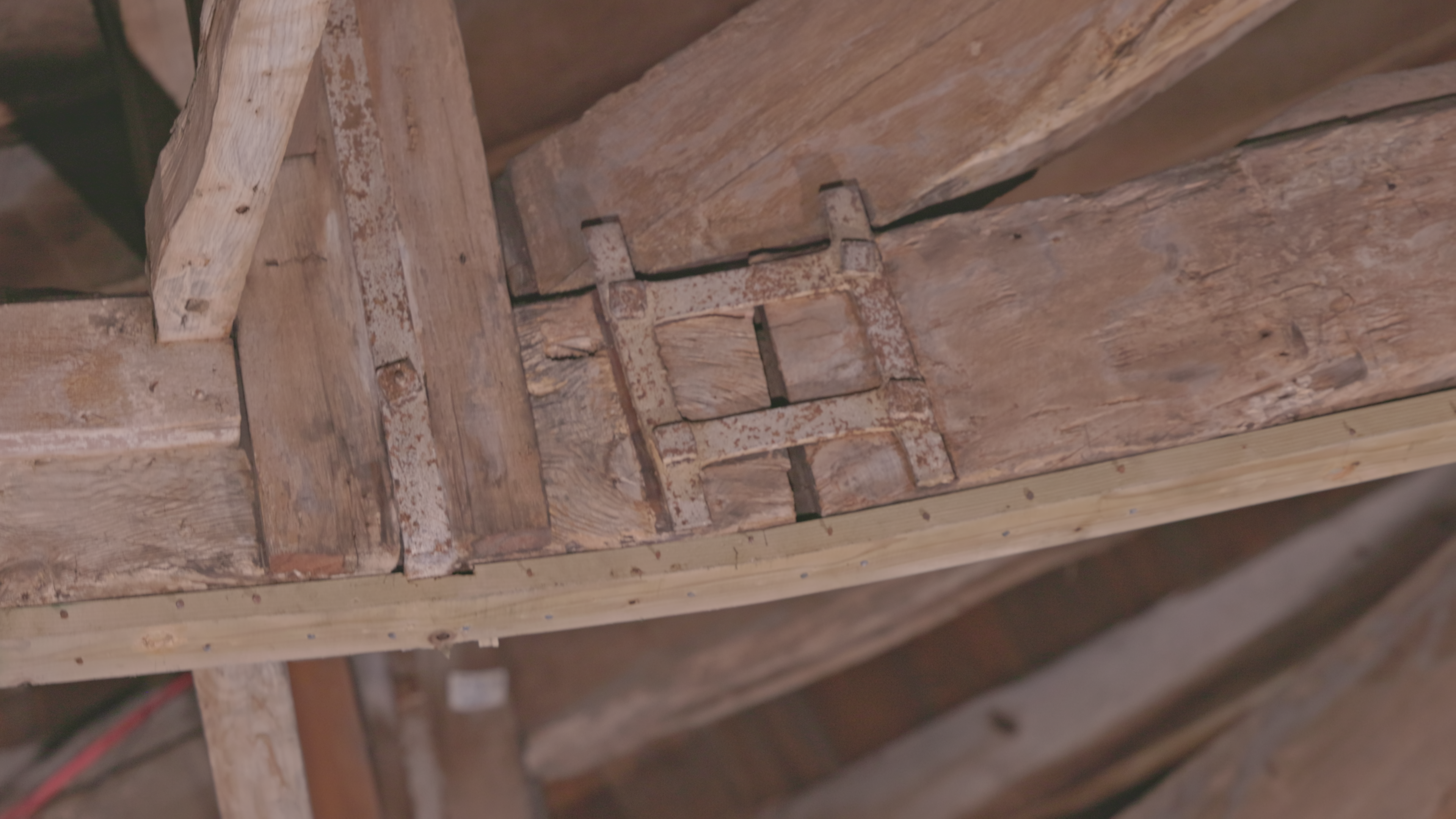 Detail of a mechanical connection at a principal rafter node. Iron strap plates and timber pegs visible.